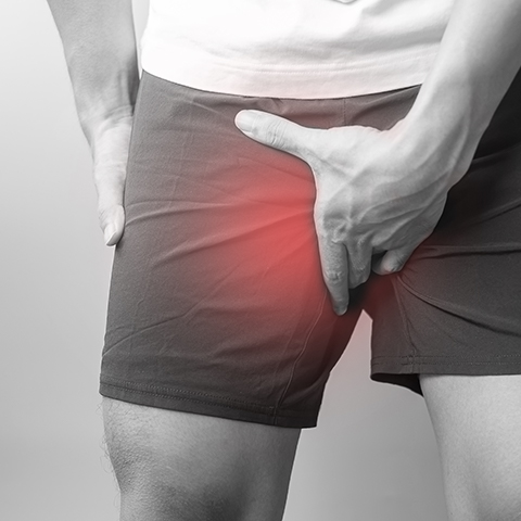a person holding his groin because of pain