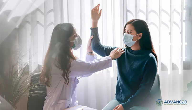An orthopaedic surgeon examining the shoulder