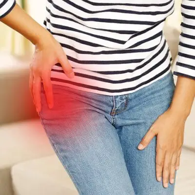 a person holding her hip because of pain