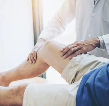 knee specialist in Singapore observing patient in pain